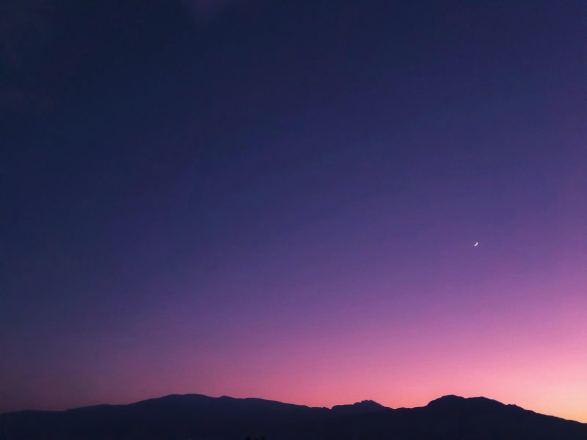 Crépuscule profond au-dessus d'une ligne de collines