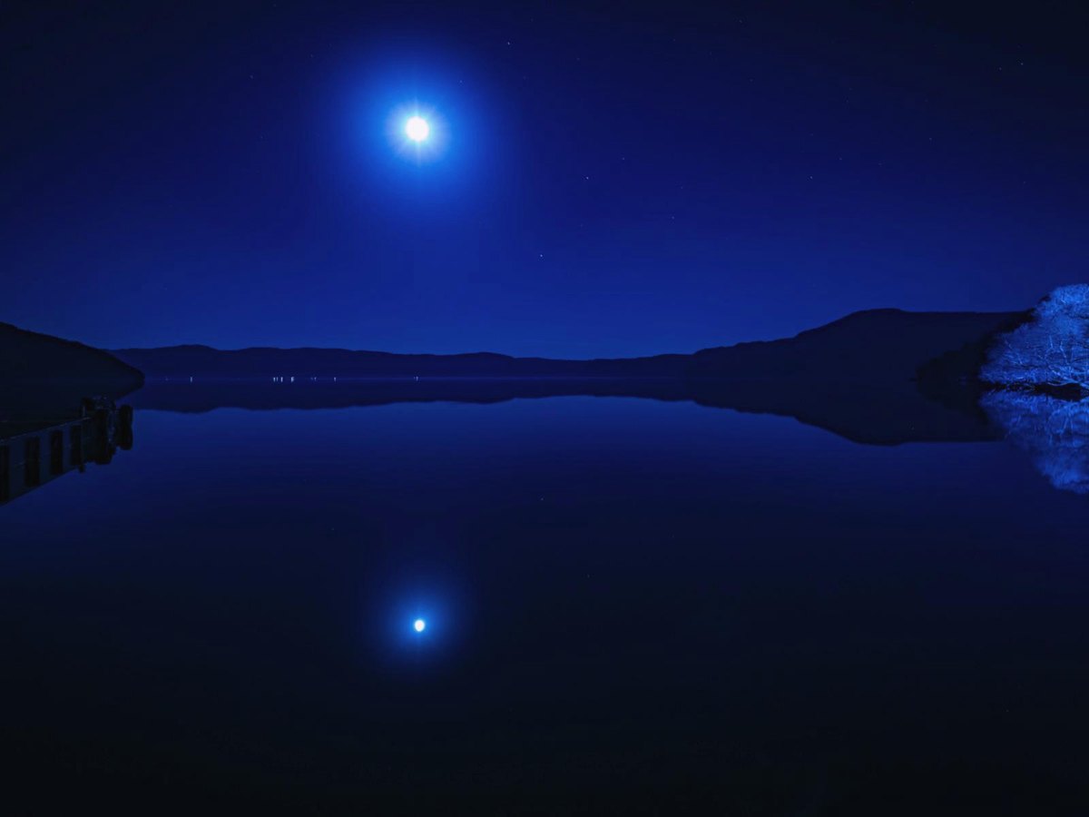 Pleine lune au-dessus d'un lac, la nuit