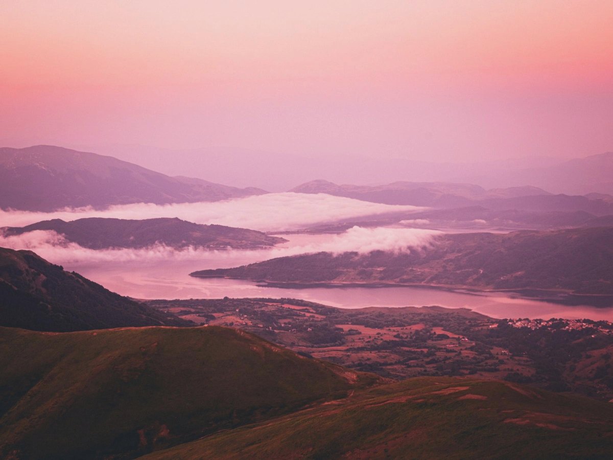 Vallée sous la brume, entre rose et lavande, à l'aube