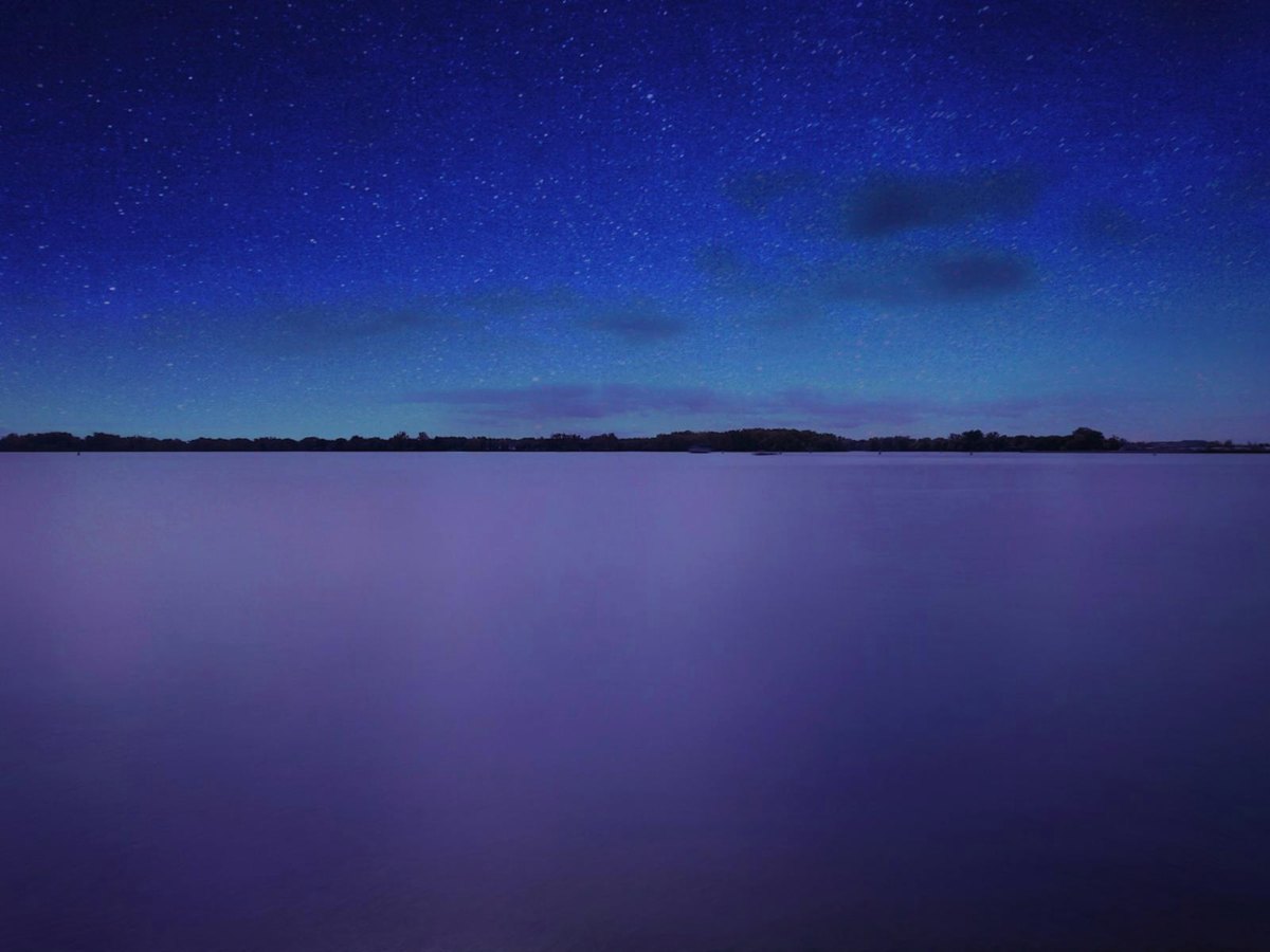 Lac immobile sous un ciel de nuit étoilé