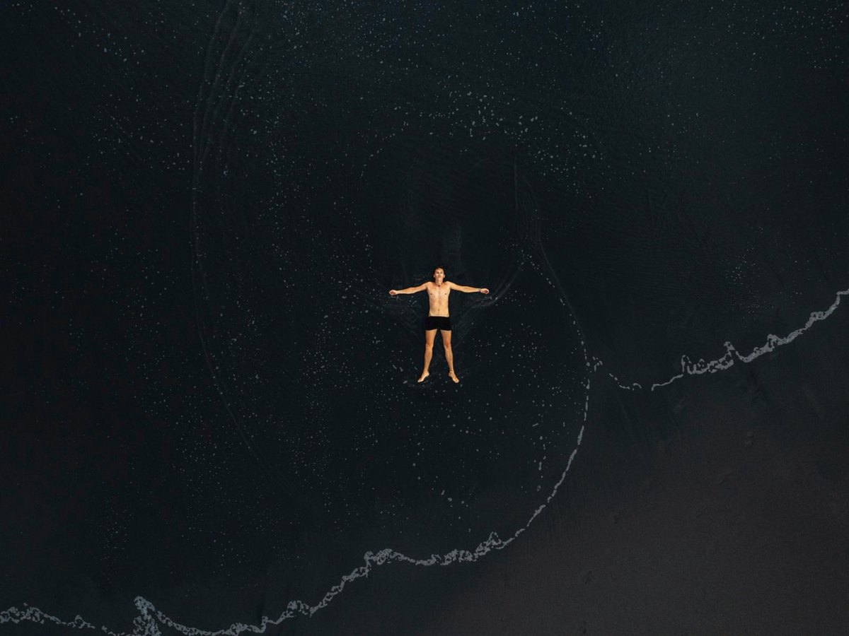 Une personne qui flotte sur une eau sombre